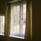 White aluminium secondary glazing face fixed into existing timber window.