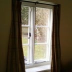 White aluminium secondary glazing face fixed into existing timber window.