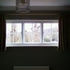 White aluminium secondary glazing face fixed into existing timber window.