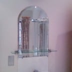Arched top 6mm thick mirror with 25mm bevelled edges, glued to fix.  6mm clear toughened glass shelf with polished edges and chrome brackets.