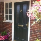 Green GRP Composite front door with a white uPVC outerframe, sidelight with surface mounted Georgian Bars and gold furniture