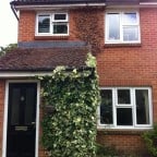 Black GRP Composite front door with a white uPVC outerframe and gold colour furniture