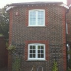 White painted hardwood windows with surface mounted Georgian Bars, Monkey Tail handles and a 4000 trickle vent in the head frame