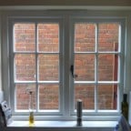 White painted hardwood windows with surface mounted Georgian Bars, Monkey Tail handles and a 4000 trickle vent in the head frame