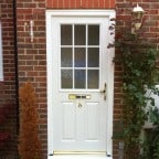 White GRP Composite front door with a white uPVC outerframe and gold furniture