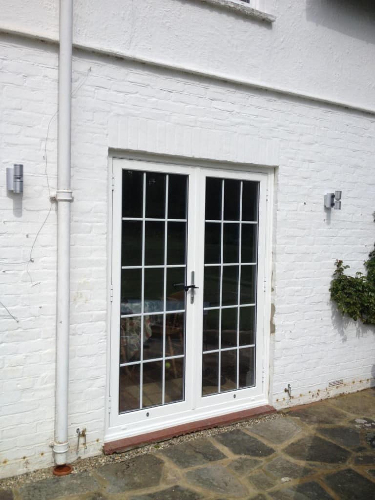 Aluminium french doors with 18mm internal Georgian Bars installed directly into brickwork with a stained hardwood cill