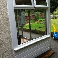 White uPVC window with white uPVC shiplap cladding below