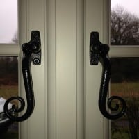 A-rated White uPVC window with fully sculptured framing, surface mounted Georgian Bars and black antique style monkeytail handles