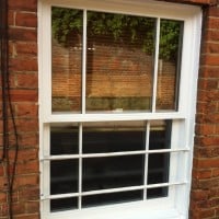 White painted hardwood sliding sash window with surface mounted Georgian Bars